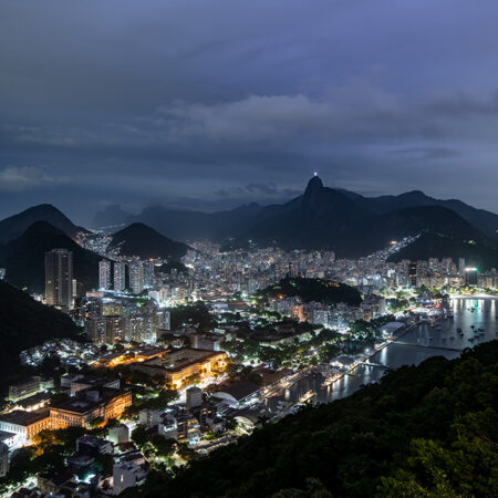 Views of the city and surrounding mountains from Sugarloaf Mountain, Pão de Açúcar in Rio De Janerio, Brazil on a cloudy night